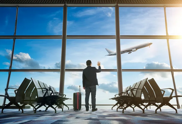 Viajero observando un avión que despega desde las ventanas de una terminal. Imagen ilustrativa; no muestra este aeropuerto.