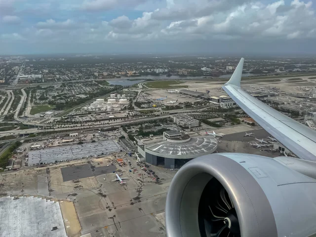Vista aérea de las terminales y pistas del Aeropuerto Internacional de Miami, junto al ala y el motor de un avión