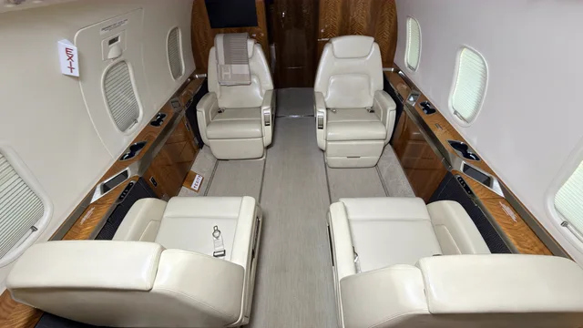 White leather seating and wood trim in a private aircraft cabin